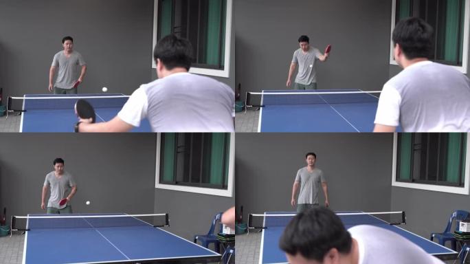 两个朋友在家打乒乓球。