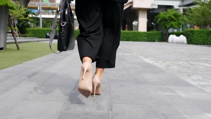 穿着高跟鞋的女商人腿带着公文包走路