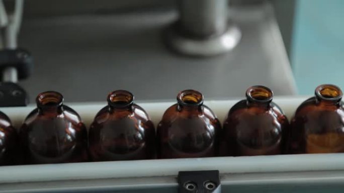 药品生产厂传送带上的棕色医疗瓶