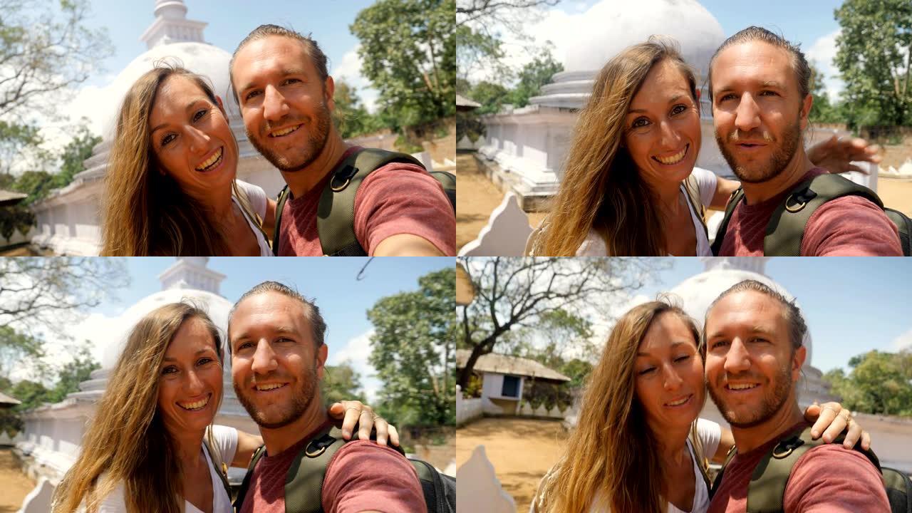 旅行夫妇在斯里兰卡佛教寺庙内拍摄自拍视频肖像。Sigiriya白色佛塔前的两个人视频自拍照