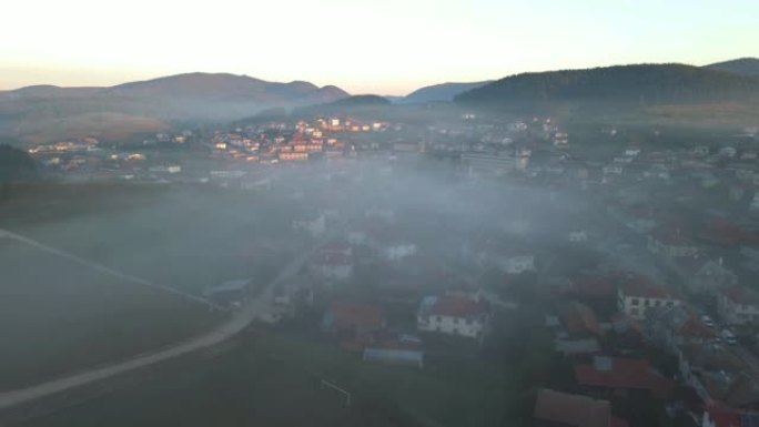 日出时带有晨雾的山村鸟瞰图。