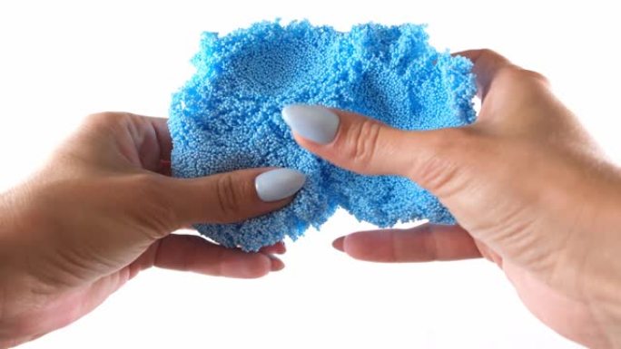女性的手由轻盈的彩色蓝色橡皮泥制成，为儿童开展活动
