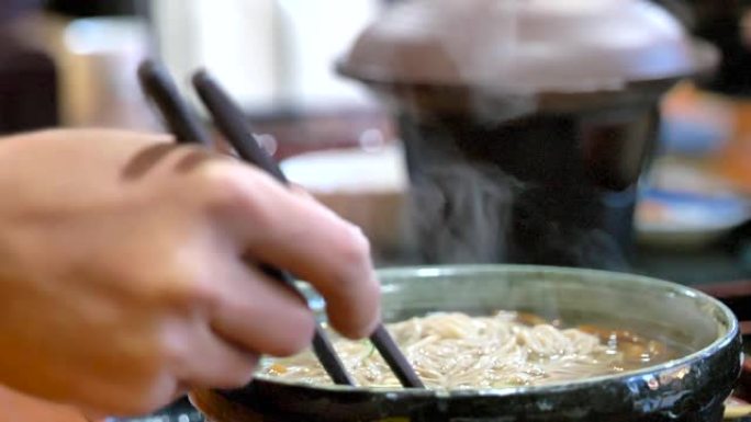 一个男人吃日本食物，烟漂浮在日本食物上