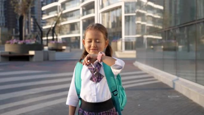穿着制服的小女孩要去上学，用手腕说话智能手表