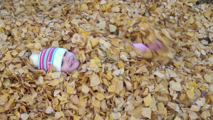 这个女孩完全把自己埋在一堆落叶里