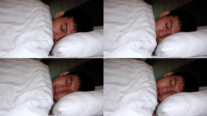 十几岁的男孩在家里的床上睡着了。