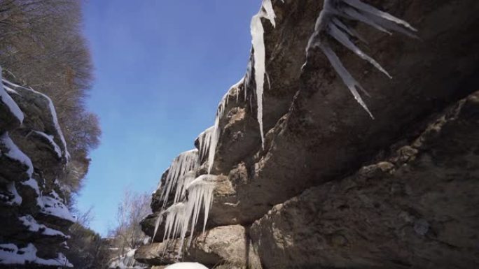 悬挂在积雪覆盖的岩石上的冰柱
