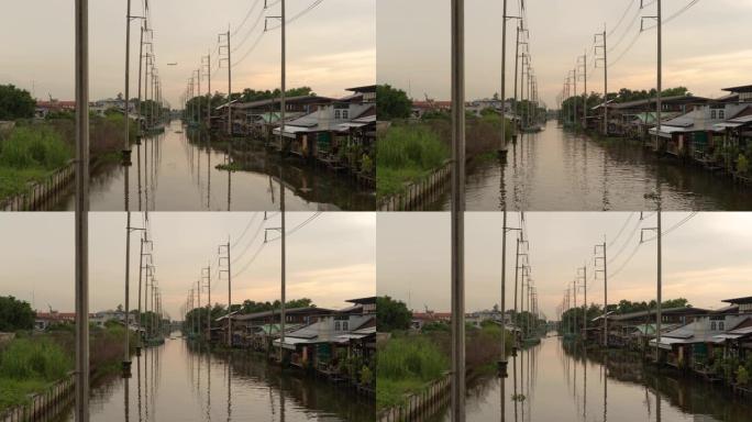 在泰国曼谷，电力技术和工业概念中，电线杆塔和电缆线以及湄南河与日落湖的倒影的时间流逝。