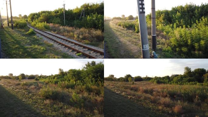 从行驶中的火车到乡下的日落。铁路路轨和轨枕。