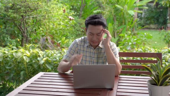 亚洲男人盯着笔记本电脑，商业损失，重仓股后感到压力