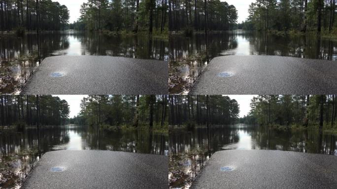 洪水淹没的道路的地面拍摄，水穿过森林和桥梁附近的道路