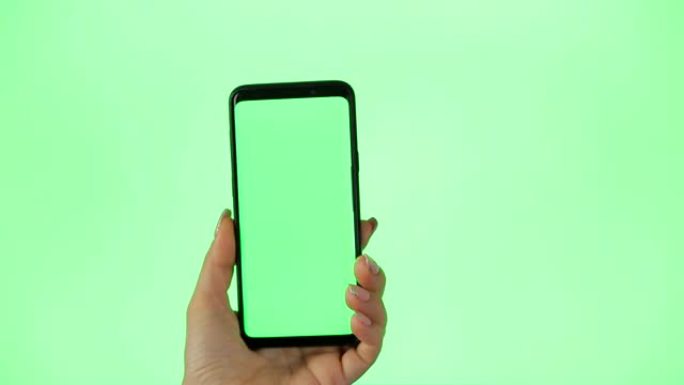 绿屏手机女人使用智能手机。女性手触摸，点击，点击，滑动，拖动和滑动色度键绿色屏幕背景