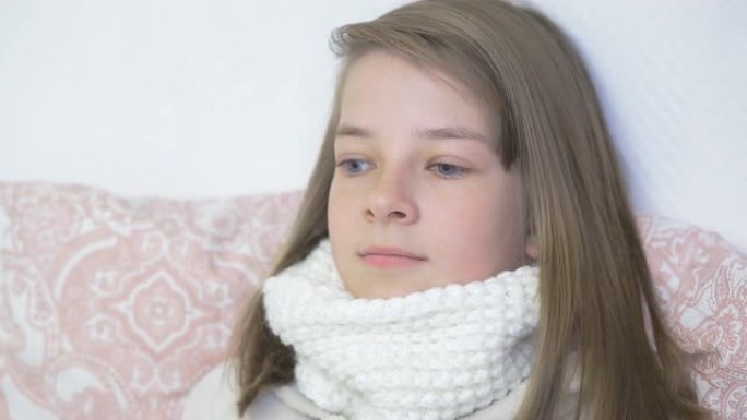 一名有感冒迹象的少女躺在床上，在家中治疗儿童的病毒性疾病