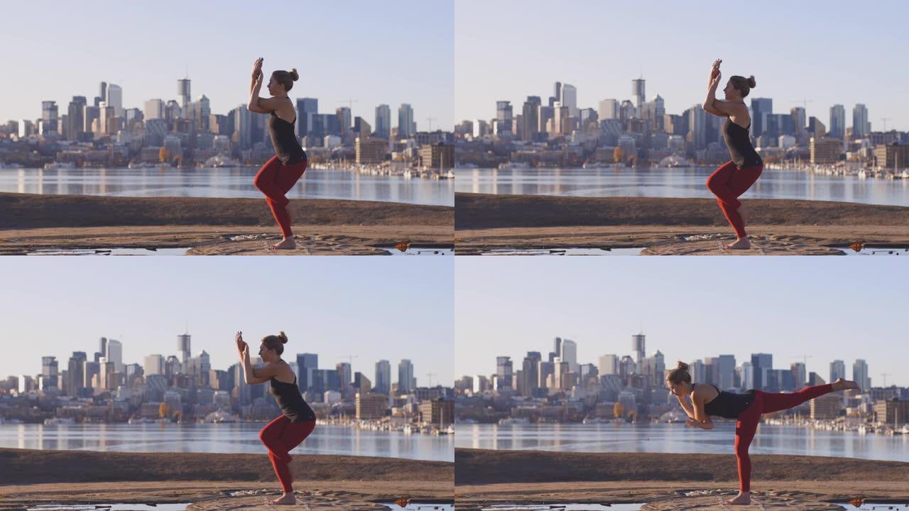 强壮的女运动员瑜伽姿势鹰和战士2姿势城市景观海滨背景在阳光明媚的早晨