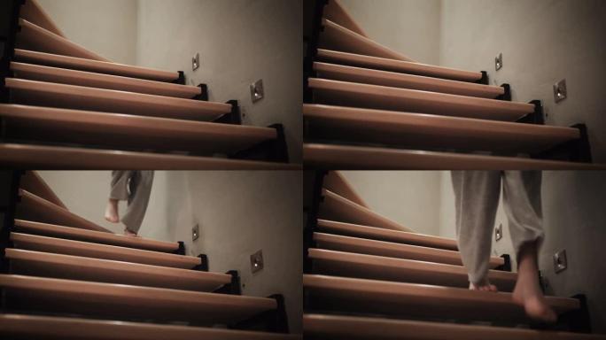 白种人妇女的赤脚腿走下木制的家庭楼梯