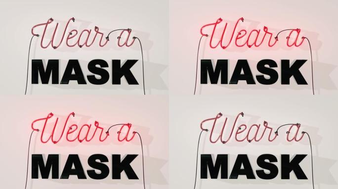 白色墙壁背景上的霓虹灯标志上写着戴口罩警告人们戴上口罩由于2020冠状病毒新型冠状病毒肺炎大流行，镜
