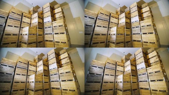苹果存储。仓库。一堆堆装水果的木箱，冷藏仓库里装着苹果的箱子。仓库里巨大的冰箱，不透气的储存摄像头。