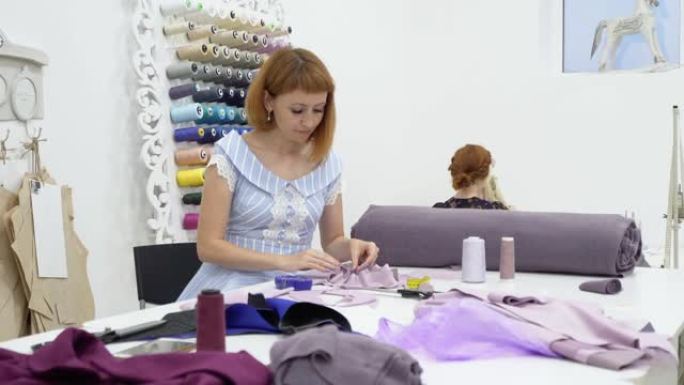 一位年轻的女裁缝时装设计师布置了将衣服制成的布料碎片。