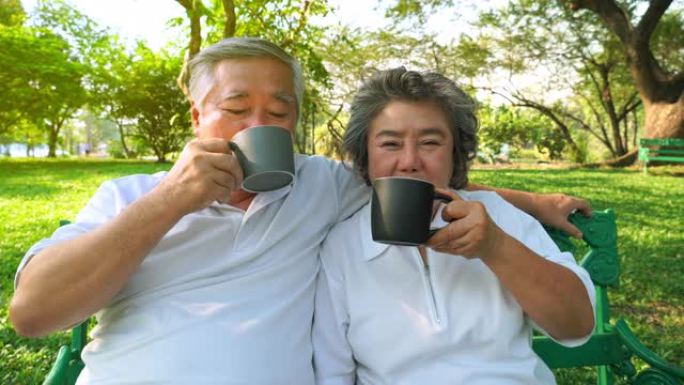 老夫妇在公园喝美味的热咖啡、热茶或人参茶。祖父，祖母在一起很开心。良好的品味，良好的健康使老年夫妇强