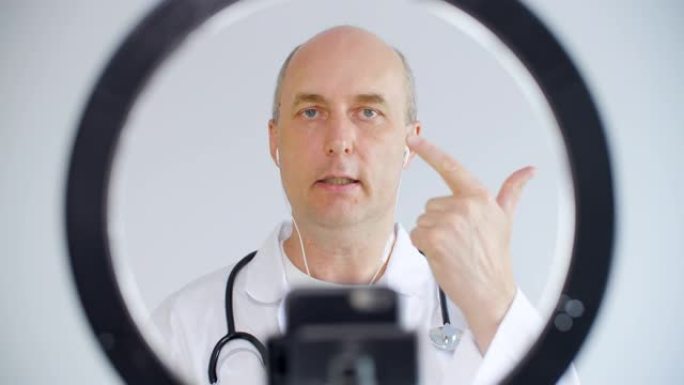 医生在远程咨询中与患者视频聊天。执业医生打手势，同时在线推荐患者在视频呼叫前置摄像头。