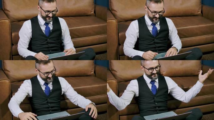 时髦商人独自坐在办公室里，用他的笔记本电脑。