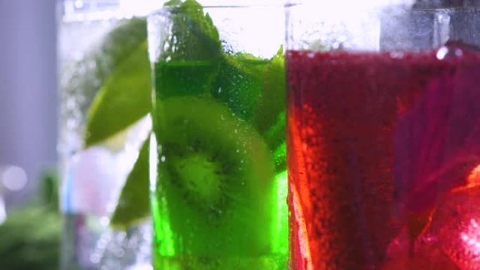 多色绿色和红色节日鸡尾酒特写。含酒精的碳酸饮料。咖啡馆的鸡尾酒会。酒吧喝鸡尾酒。玻璃莫吉托。冷饮液体