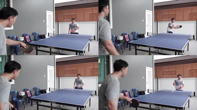 两个朋友在家打乒乓球。