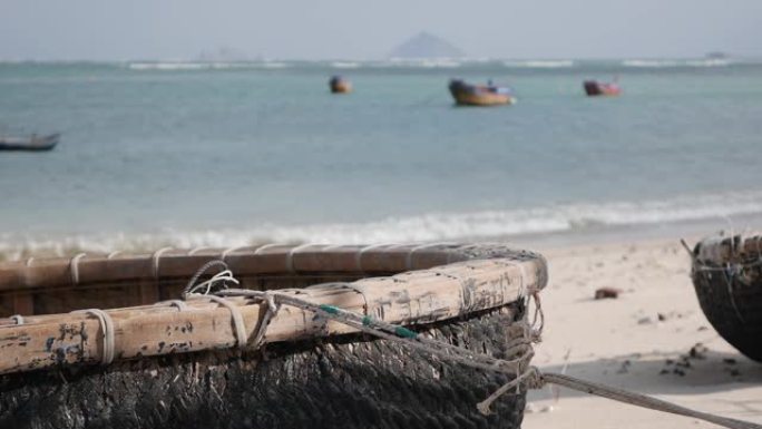 传统的越南圆船在海上背景渔村的沙滩上。渔船和文化象征