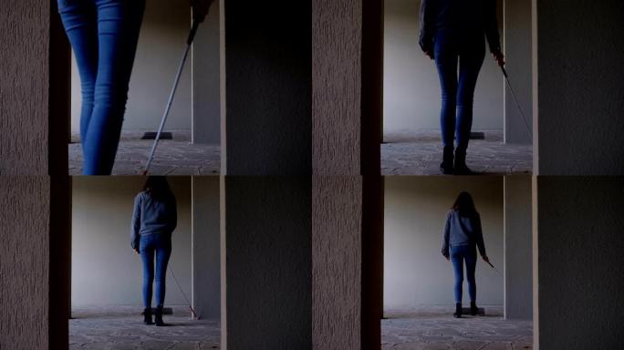 盲人妇女在空荡荡的公寓里用棍子走路。失明，自治，定向