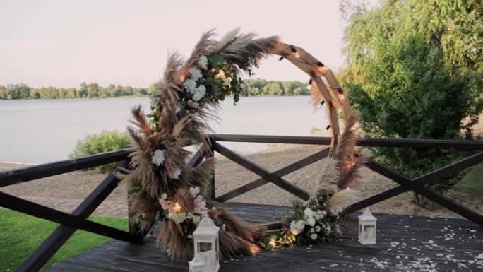 日落时带鲜花的圆形婚礼拱门