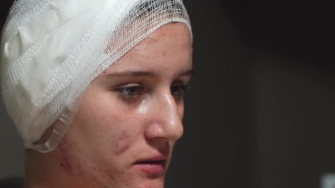 头部手术后头部受伤的妇女坐在床上缠着绷带