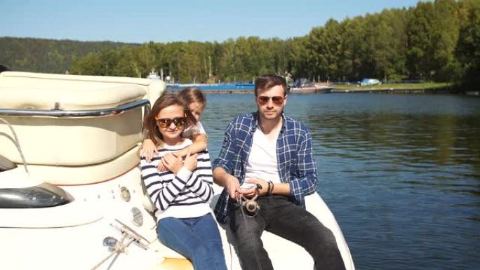带着女儿的家人一起在湖边的帆船上度假
