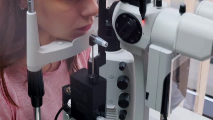 眼科治疗-一名年轻女子用机器检查她的视力-瞳孔对光的反应投掷镜片