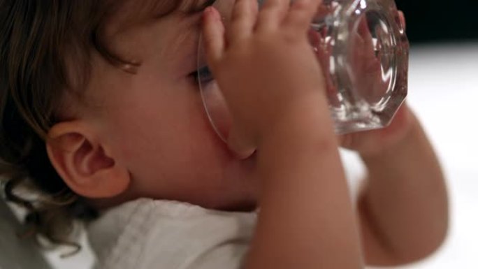 婴儿喝玻璃水，口渴的蹒跚学步的男孩喝水