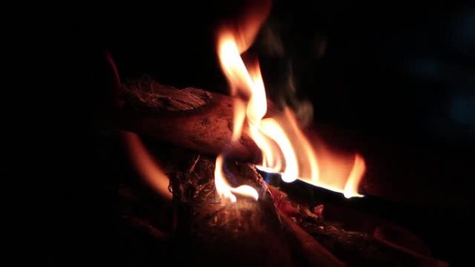 晚上在河岸边燃烧着炽热的柴火和火花露营。美丽的抽象背景火火花粒子在黑色背景。