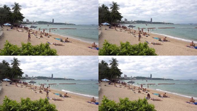 芭堤雅海滩，人们放松，享受日光浴，游泳。