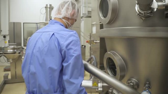 实验室药厂工人检查和调整生产钢机和容器