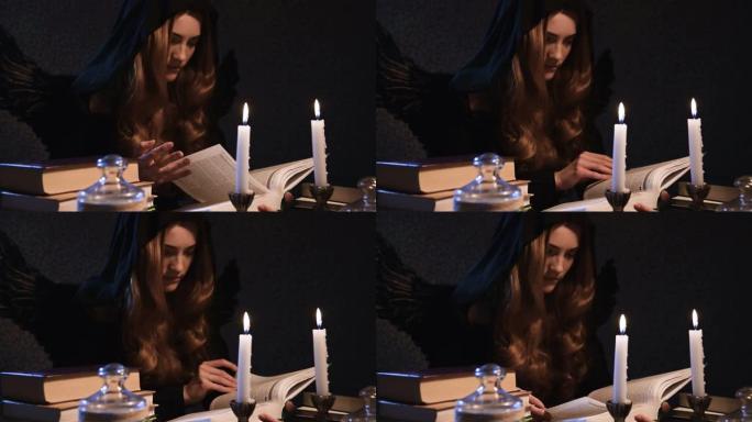 中等特写迷人的白人女孩，金色长发，黑色兜帽，坐在桌子旁，翻阅一本书。有翅膀的服装。蜡烛在燃烧。万圣节