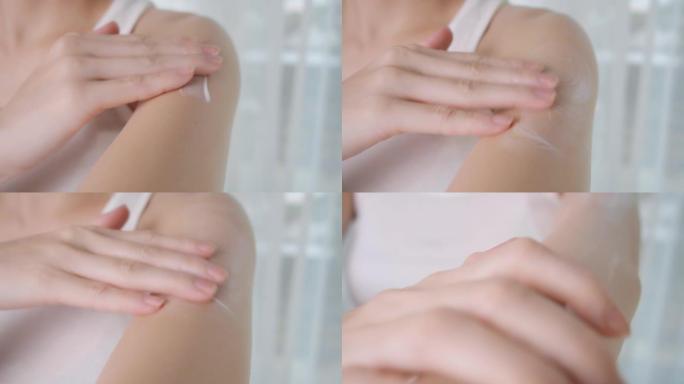 亚洲妇女在家庭工作室将乳液涂在手臂上。白霜擦洗治疗皮肤状况。