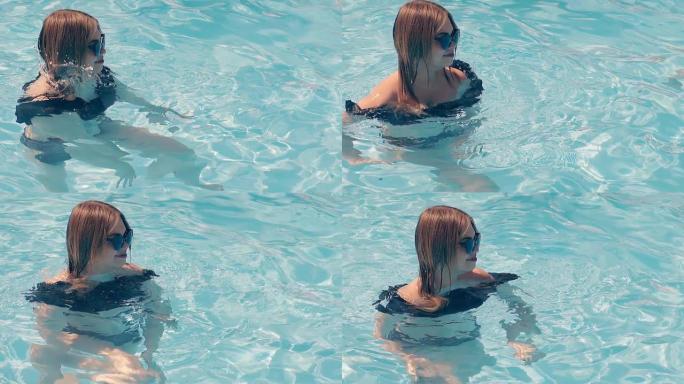 海滩上的女孩在水中游泳，同时练习水中有氧运动。