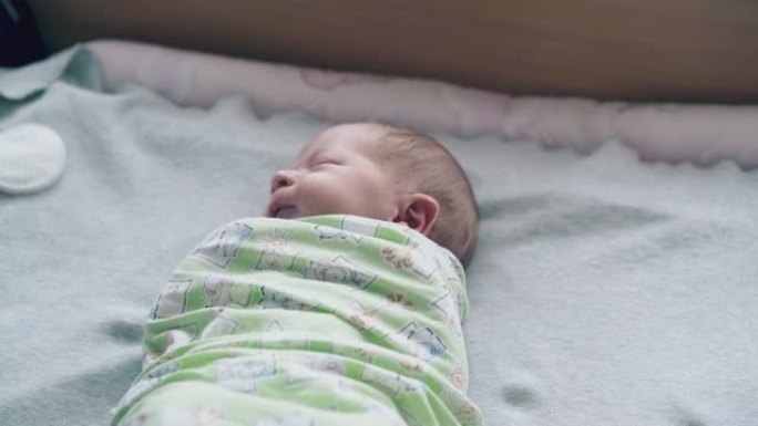 闭着眼睛，白发的新生婴儿躺在襁褓中