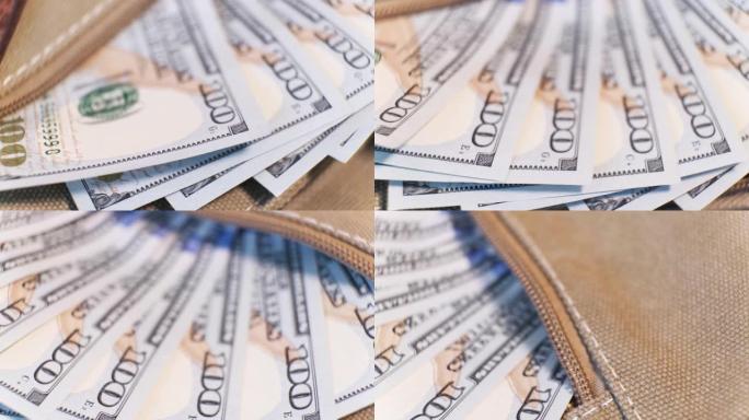 一组100美元的美国纸币在一个帆布袋口袋在旋转桌上。特写，浅景深。