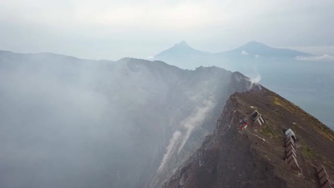 人们站在活跃的Nyiragongo火山的火山口边缘，熔岩湖冒烟