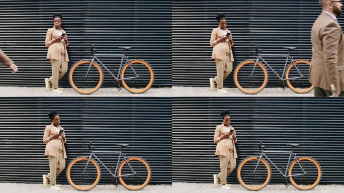 非洲裔美国妇女在街上骑自行车使用智能手机