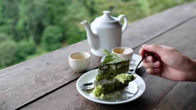 一个女人在木棒上切茶壶和吃绿茶蛋糕