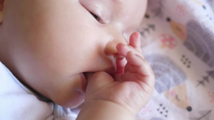 饥饿的小婴儿婴儿新生儿吮吸手指拇指睡觉