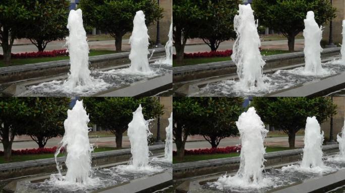 泡沫状的水流上升和下降。城市公园的喷泉小巷。