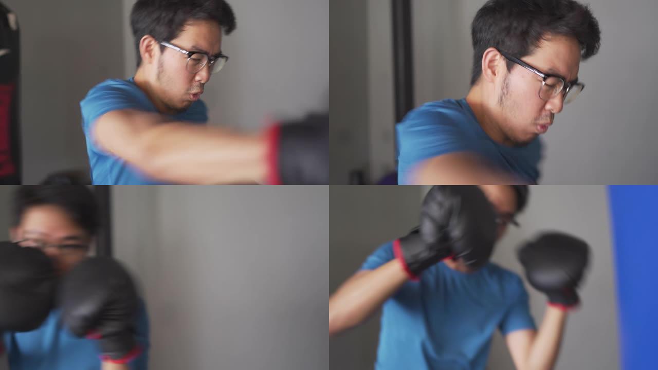瘦瘦的亚洲拳击手在健身房用沙袋训练
