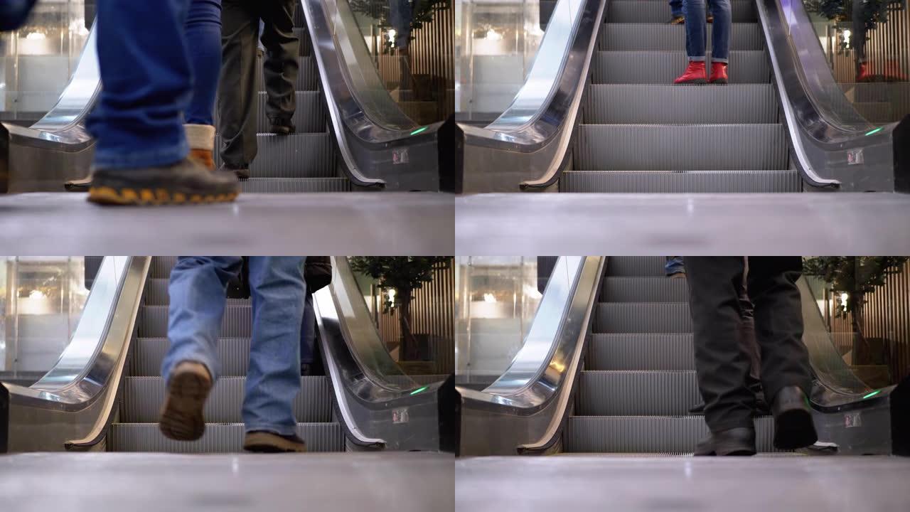 人们在购物中心的自动扶梯上移动的腿。购物中心自动扶梯上的购物者脚