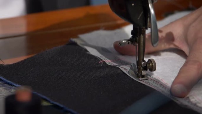裁缝在缝纫机上缝制两块布的镜头